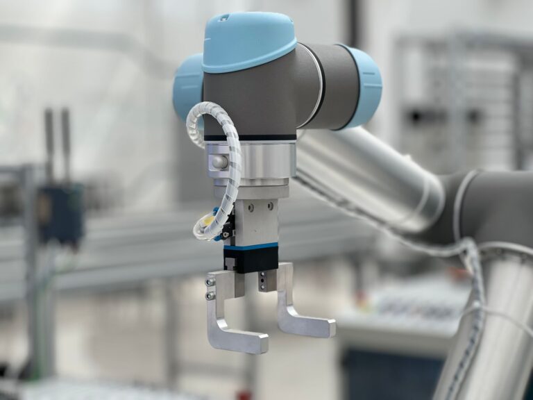 Close-up de um braço robótico em um ambiente industrial moderno, destacando a tecnologia.