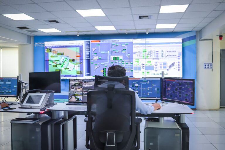 Operador em uma moderna sala de controle gerenciando sistemas tecnológicos em El Agustino, Lima.
